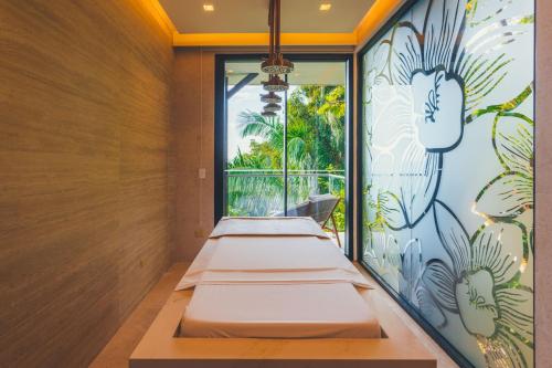 a row of beds in a room with a window at Los Altos Resort in Manuel Antonio