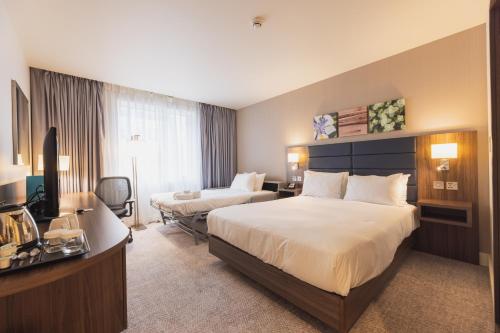 a hotel room with two beds and a television at Hilton Garden Inn Birmingham Airport Uk in Bickenhill