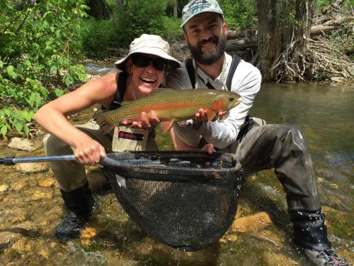 a man and a woman holding a fish in a net at Days Inn by Wyndham Spearfish in Spearfish