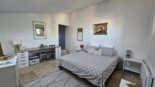 a bedroom with a bed and a desk and a desk at Appartement typique in Pertuis