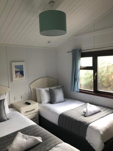 a bedroom with two beds and a window at Beverley Park in Goodrington