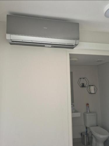 a bathroom with a toilet and a television on the ceiling at Tettey Haven Millennial in Durban