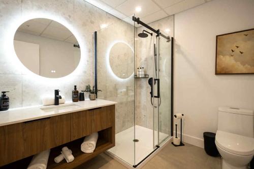 a bathroom with a shower and a sink and a toilet at La Capitainerie du Lac-Mégantic in Lac-Mégantic
