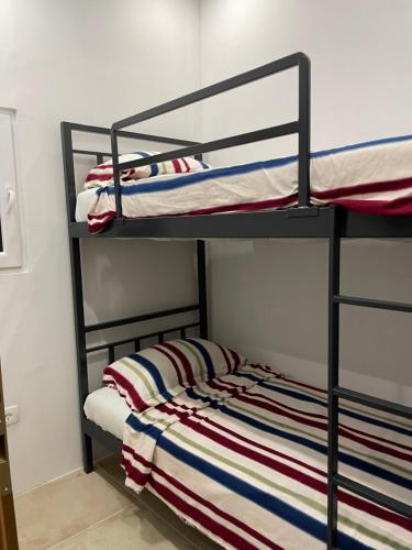 a bedroom with two bunk beds with a striped blanket at Apartmani PARADISO in Čapljina