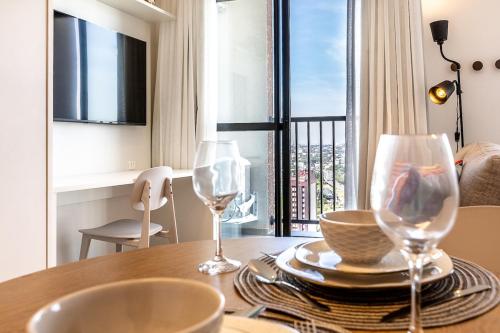 a dining room table with two wine glasses on it at Ibiza 2410 · Vista incrível: Piscina, Academia e Bem Localizado in Curitiba