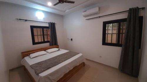a bedroom with a bed and two windows at Villa Moderne 4 Chambres avec Suite in Loué