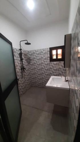 a bathroom with a sink and a light on the wall at Villa Moderne 4 Chambres avec Suite in Loué