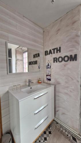 a bathroom with a sink and a bath room sign at La Flambée in Blond