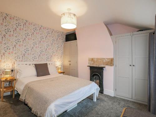 a bedroom with a bed and a fireplace at 5 Belper Lane End in Belper