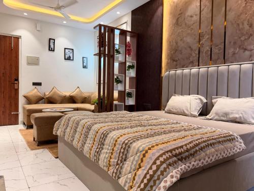 a bedroom with a large bed and a couch at PATEL Residency in Ghaziabad