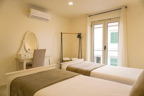 a hotel room with two beds and a mirror at South Shore 2 - Jacuzzi - HOST & CHILL in São Roque