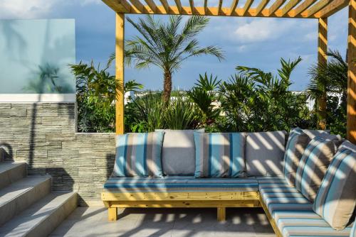 a blue couch sitting under a pergola on a patio at Newport House Playa Boutique Hotel in Playa del Carmen