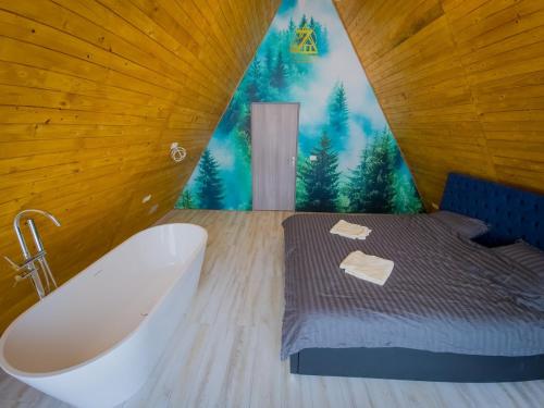 a bathroom with a bath tub and a bed with a mural at Cabana Z-Haven in Ungureni