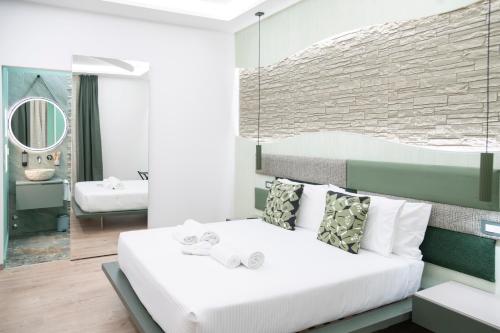 a bedroom with a white bed and a mirror at Giulio Cesare Luxury Rooms in Rome