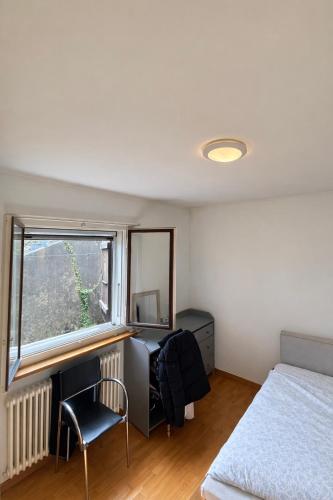 a bedroom with a bed and a desk and a window at Lake View near Lucerne in Hergiswil
