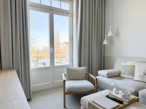 a living room with a couch and a chair and a window at Villa Astoria - Kühlungsborn in Kühlungsborn