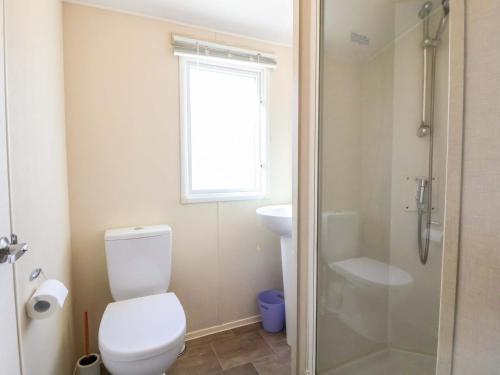 a bathroom with a toilet and a sink and a shower at Dunes View in Prestatyn