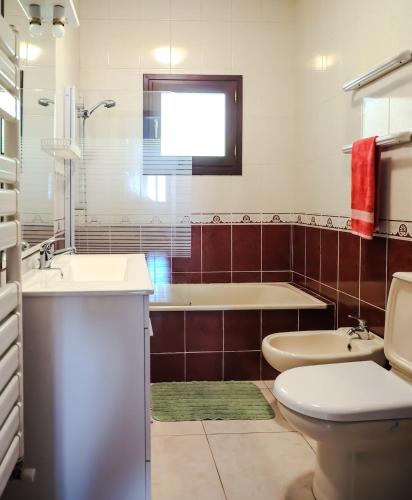 a bathroom with a tub and a toilet and a sink at Casa do Batoco in Vieira do Minho