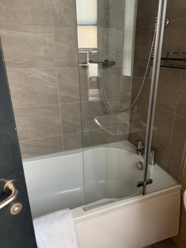 a shower with a glass door next to a bath tub at City Centre-Contactors-Professionals-Luxury Apartment in Nottingham