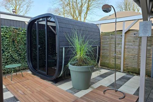 a black building with a plant in a pot on a deck at Wellness Villa voor 6 personen incl Sauna & Hottub in Meerssen