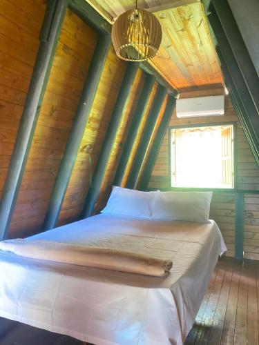 a bed in a room with a wooden ceiling at Pousada Recanto dos Chalés - Itambé do Mato Dentro in Itambé do Mato Dentro