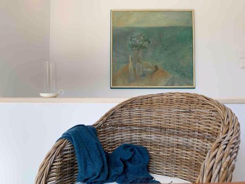 a wicker chair with a blue blanket on it at Anassa Boutique Beach House in Sami