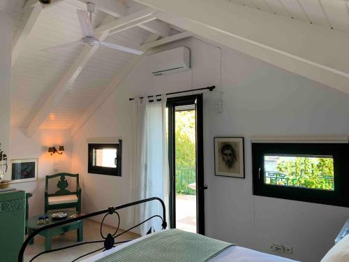 a bedroom with a bed and a ceiling fan at Anassa Boutique Beach House in Sami