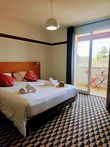 a bedroom with a large bed and a large window at La Maison des Ocres - Provence in Roussillon