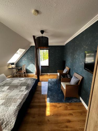 a bedroom with a bed and a couch and a tv at Hotel Wurster Kroog in Bremerhaven