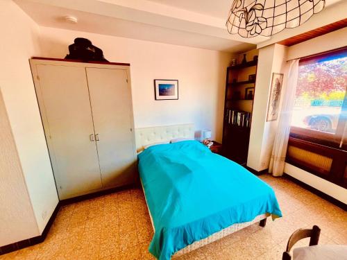 a bedroom with a blue bed and a cabinet at Le Petit Ousson Studio avec Jardin in Briare