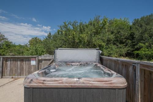 a hot tub sitting next to a wooden fence at 3218 - Swab The Duck in Duck
