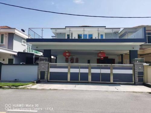 a house with a gate and a garage at Sweetsweet homestay in Banting