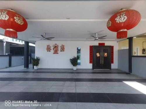 a hallway with red lanterns and a door in a building at Sweetsweet homestay in Banting