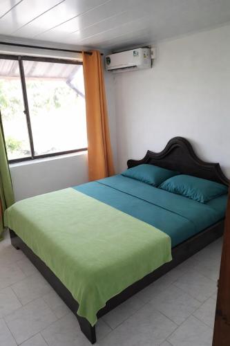 a bedroom with a bed with blue and green sheets at Miss Leila in San Andrés