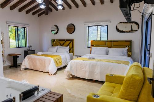 a bedroom with two beds and a couch at Ecohotel Dubai del Oriente in El Peñol