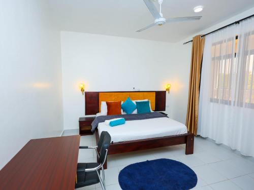 a bedroom with a bed and a blue rug at Ntate Homes, Diani Near the Beach in Diani Beach