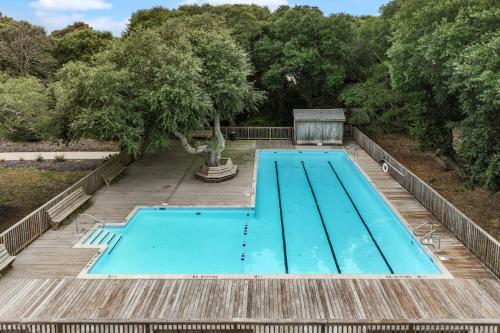 an empty swimming pool in a yard with trees at 4208 - Naan Sands in Duck