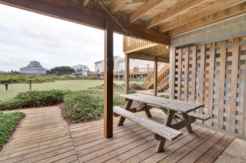 a wooden deck with a picnic bench on a house at 4209 - Moby Duck in Duck