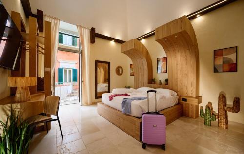 a bedroom with a large bed with a purple suitcase at Mamaco Trani in Trani