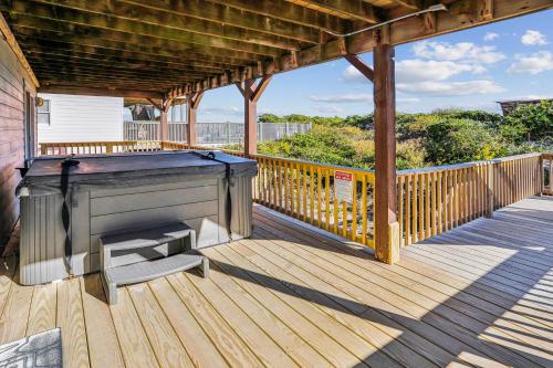 a large wooden deck with a piano and a bench at 5437 - WeekAway in Nags Head