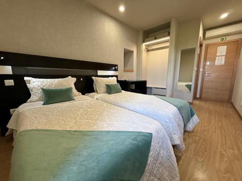 a hotel room with two beds in a room at Residencial Portas do Sol in Valença