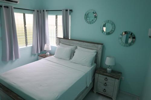 a bedroom with a bed and two mirrors on the wall at Villa Blue Nights in Saint James