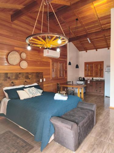 a bedroom with a large bed and a kitchen at Aconchego da Serra in São Joaquim