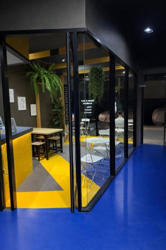 a room with glass doors and a yellow and blue floor at Free Way Kata Beach Hostel in Kata Beach