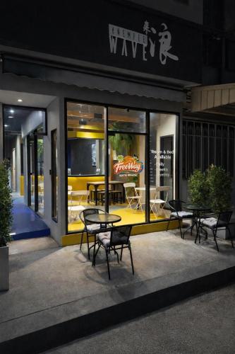 a group of tables and chairs outside of a restaurant at Free Way Kata Beach Hostel in Kata Beach