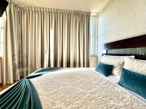 a bedroom with a large bed with blue pillows at Residencial Portas do Sol in Valença