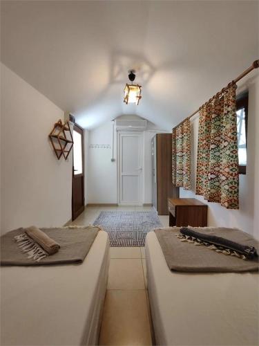 two beds sitting in a room with a hallway at 7 Garden Bungalow / Camping in Kumluca