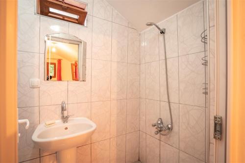 a white bathroom with a sink and a shower at 7 Garden Bungalow / Camping in Kumluca