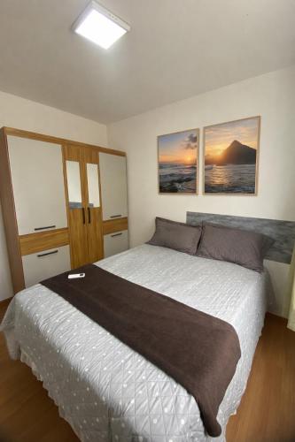 a bedroom with a large bed with two pictures on the wall at Ilha Aruba Condomínio na Cohama próx a praia in São Luís