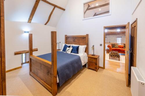 a bedroom with a bed with a blue bedspread at Hillside Barn in Gimingham